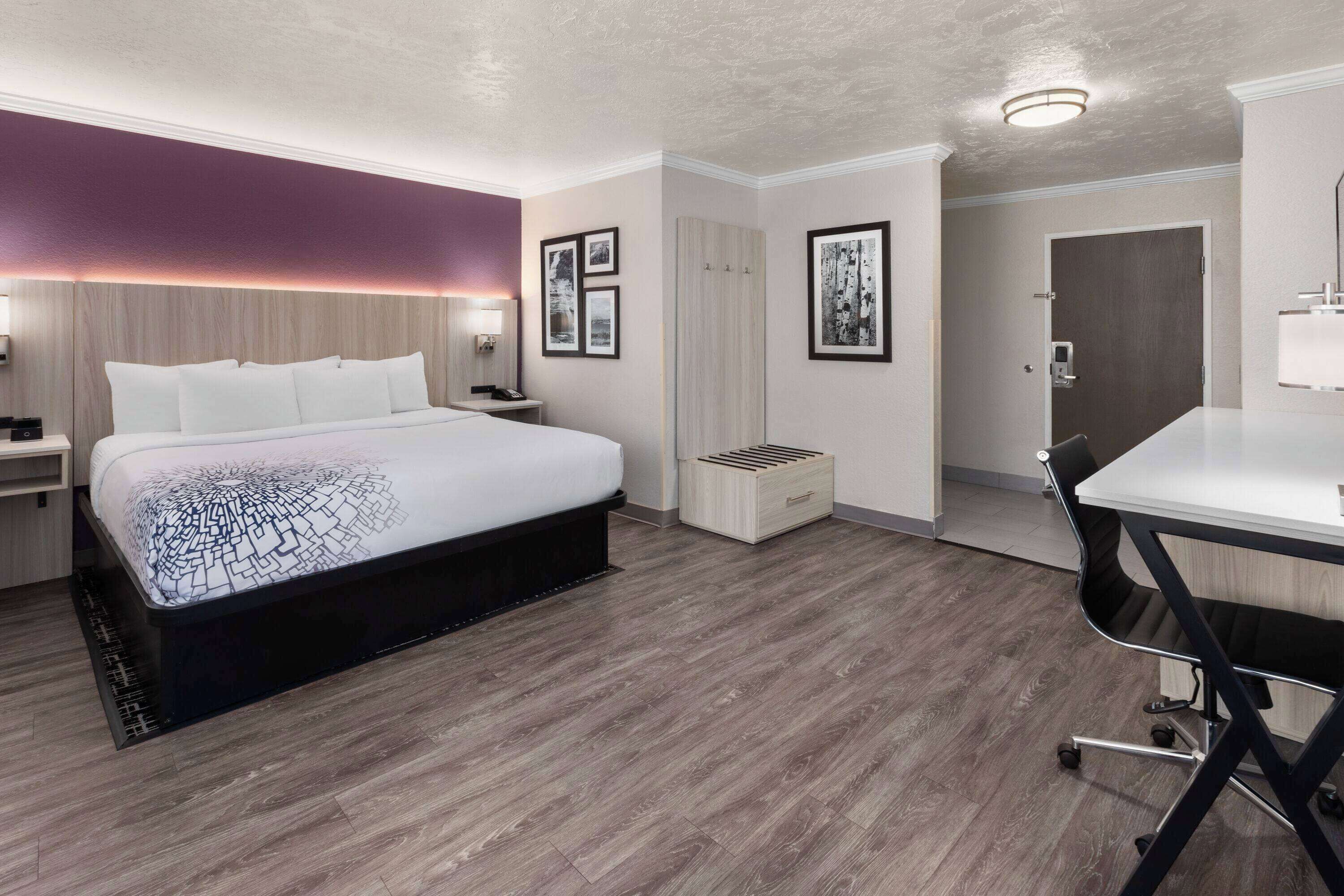 Una habitación de hotel moderna con una cama grande, un escritorio y una silla.