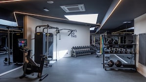 A modern gym with exercise equipment, a motivational wall, and a skylight. - Holiday Inn Express and Suites Lisbon Principe Real by IHG (Lisbon)
