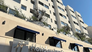 A Holiday Inn Express & Suites building with a modern architectural design, featuring multiple windows and balconies with greenery. - Holiday Inn Express and Suites Lisbon Principe Real by IHG (Lisbon)