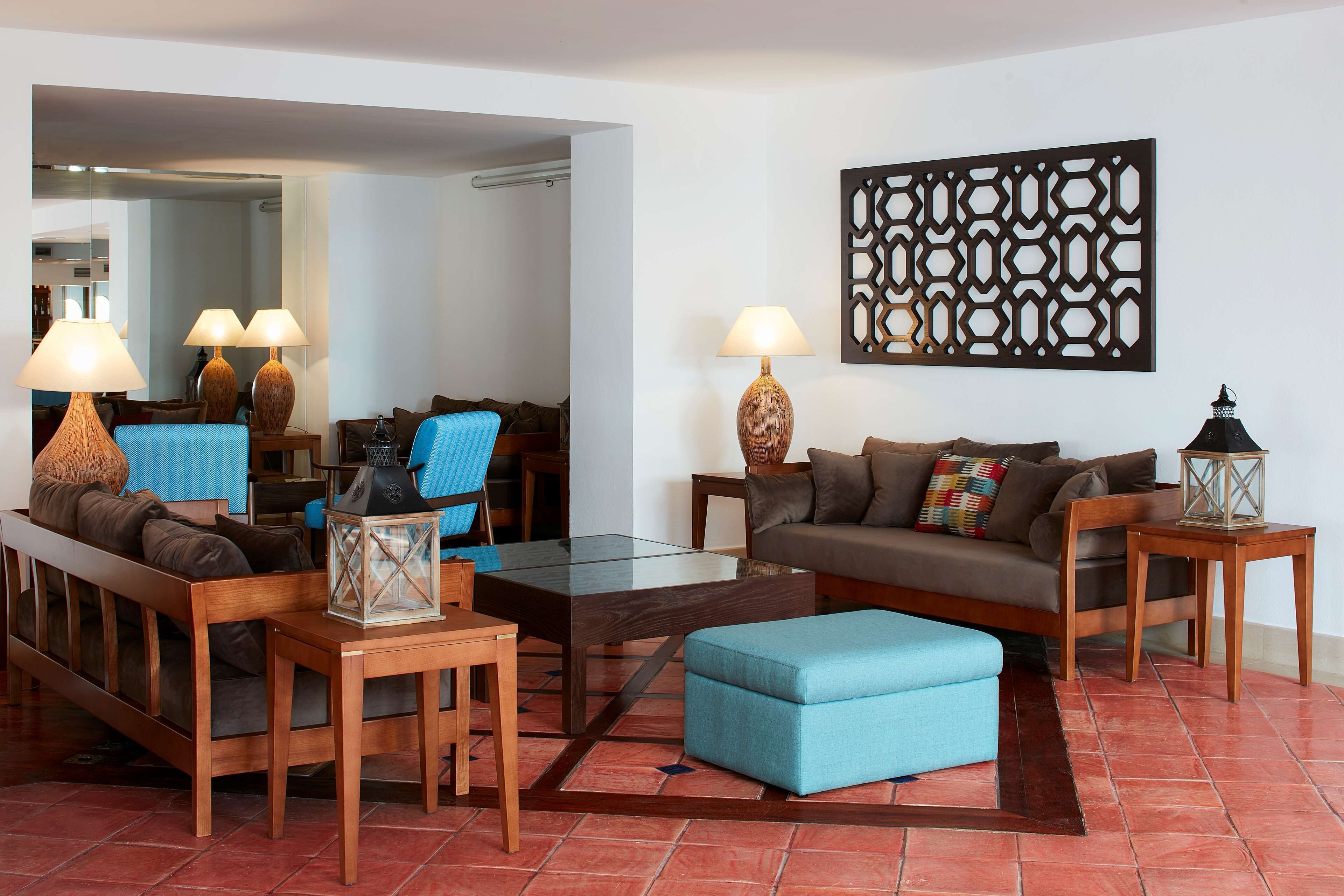 A living room with a sofa, armchair, coffee table, and lamps.