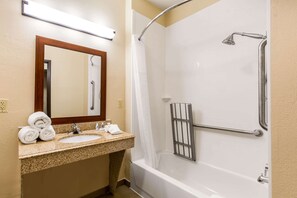 Bathroom features a sink, mirror, shower with handheld showerhead, and towel rack.