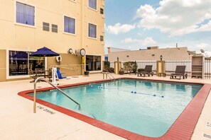 Relax by the pool surrounded by lounge chairs and umbrellas.