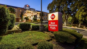 A Best Western Plus hotel sign with a clear view of the building's entrance and well-maintained landscaping. - Best Western Plus Hill Country Suites (San Antonio)