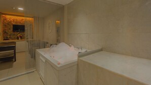 A modern bathroom with a large bathtub, a separate shower area, and a vanity with a mirror. - Best Western Plus Khan Hotel (Antalya)