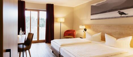 A hotel room with two beds, a desk, and a chair.