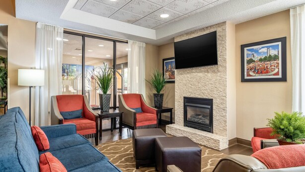 A hotel lobby with a fireplace, comfortable seating, and a television. - Comfort Inn & Suites Atlanta/Smyrna (Smyrna)