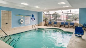 An indoor swimming pool with clear blue water, a lifeguard stand, and blue chairs near the window. - Comfort Inn & Suites Atlanta/Smyrna (Smyrna)