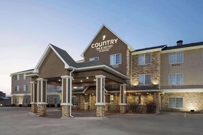 A Country Inn & Suites by Radisson building with a prominent entrance, stone facade, and multiple windows.
