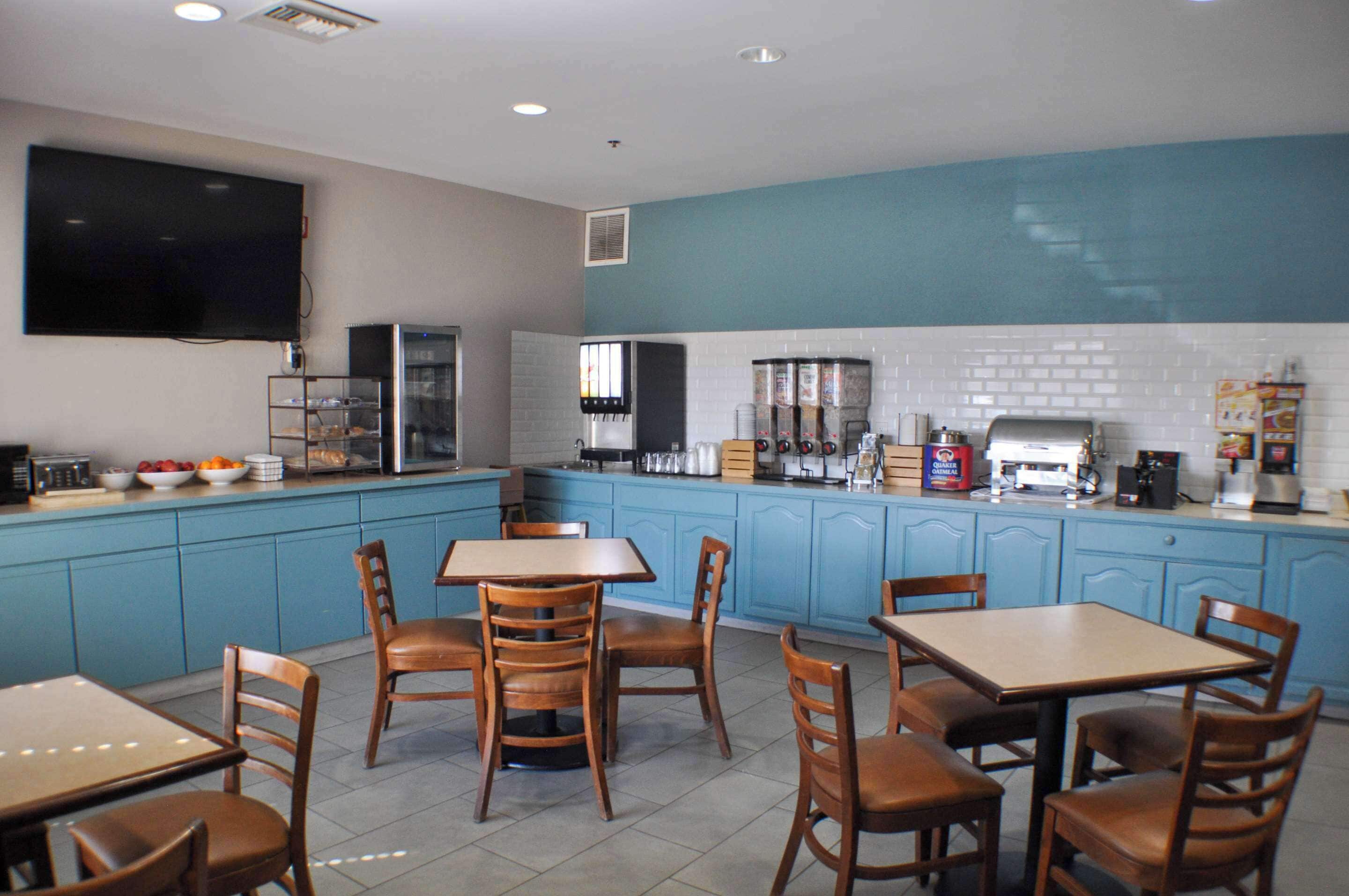 Un restaurante con gabinetes azules, un televisor de pantalla plana y una cafetera.