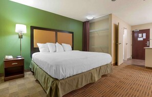 A hotel room with a large bed, a bedside table with a lamp, a wardrobe, and a door. - Extended Stay America Suites Chicago Schaumburg I90 (Schaumburg)