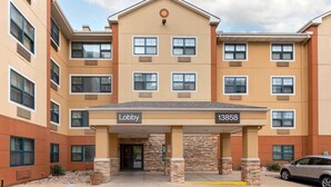 A multi-story hotel with a beige facade, a lobby entrance, and a parking area. - Extended Stay America Select Suites - Austin - Northwest - Lakeline Mall (Austin)