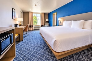 A hotel room with a large bed, a desk with a computer, a chair, and a window with curtains. - Comfort Inn & Suites Lancaster Antelope Valley (Lancaster)
