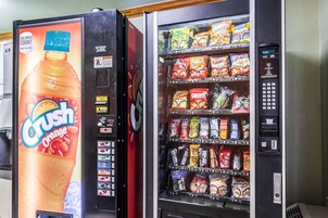 Een automaat met Crush Orange drank en diverse snacks.
