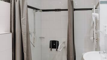 A modern bathroom with a shower, toilet, and sink.