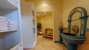 Un baño con lavamanos, toallero y zona de ducha.