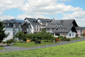 Une rangée de maisons modernes, avec un bâtiment central portant l’inscription « Hôtel Zum Parkhaus ».