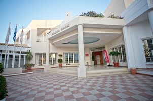 Un hotel con suelo a cuadros, un balcón y varias banderas.