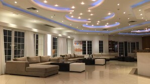 Un amplio espacio habitable con muebles modernos, ventanas grandes y un techo decorativo.