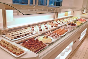 A buffet with various desserts and fruits.