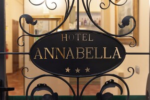 A sign for Hotel Annabella with a classic design and three stars.