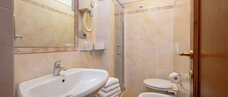 A bathroom with a sink, toilet, and glass shower enclosure.