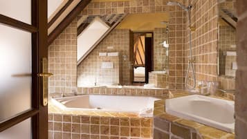 Une salle de bain avec une grande baignoire, une douche et un miroir.