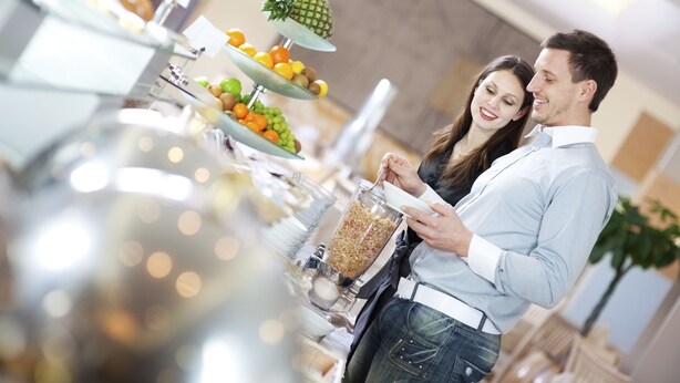 A buffet setup with various fruits and a beverage dispenser. - Elba Vecindario Aeropuerto Business & Convention Hotel (Santa Lucia)