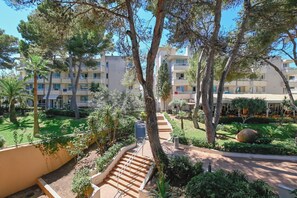 A multi-story building with balconies, surrounded by lush greenery and trees. - Club Hotel Cala Ratjada (Capdepera)