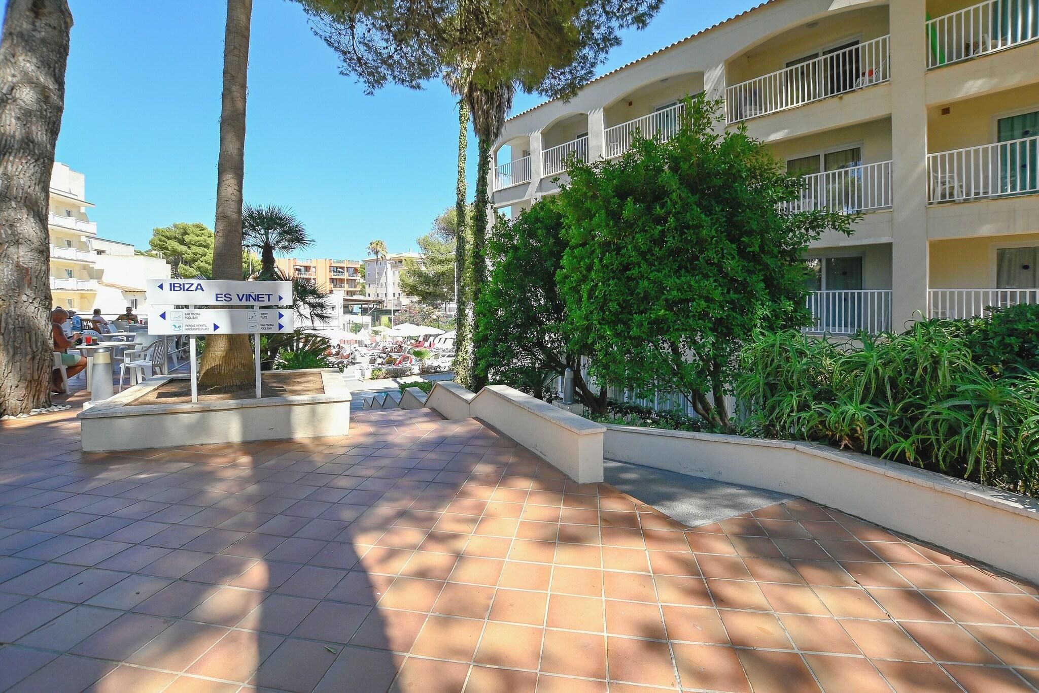 Patio de hotel con un cartel que indica indicaciones hacia Ibiza y Es Vinet.