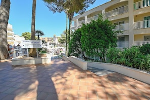 Een hotel binnenplaats met een bord waarop de wegwijzers naar Ibiza en Es Vinet staan.