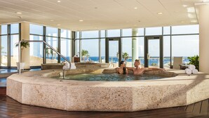 A hot tub area with a view of the sea, a palm tree, and a chair. - Insotel Punta Prima Resort & Spa (Sant Lluis)