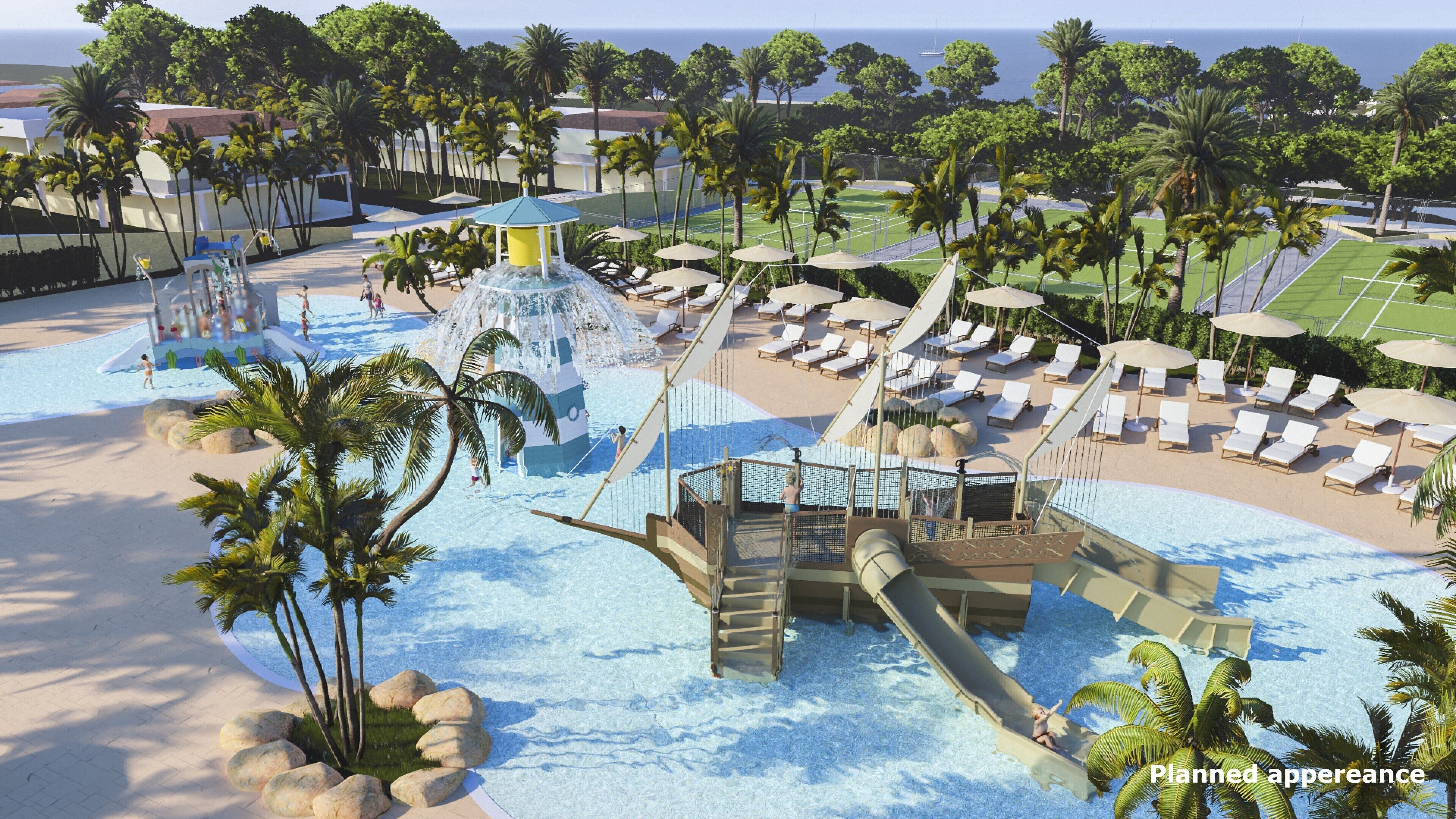A resort with a water park, lounge areas, and a view of the ocean.