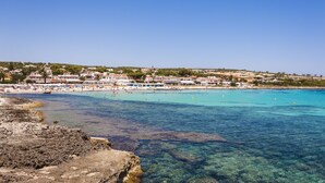A coastal town with clear blue waters, sandy beaches, and buildings along the shore. - Insotel Punta Prima Resort & Spa (Sant Lluis)