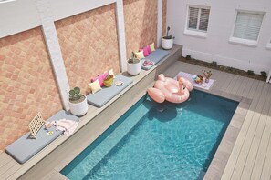 Una piscina al aire libre, tumbonas