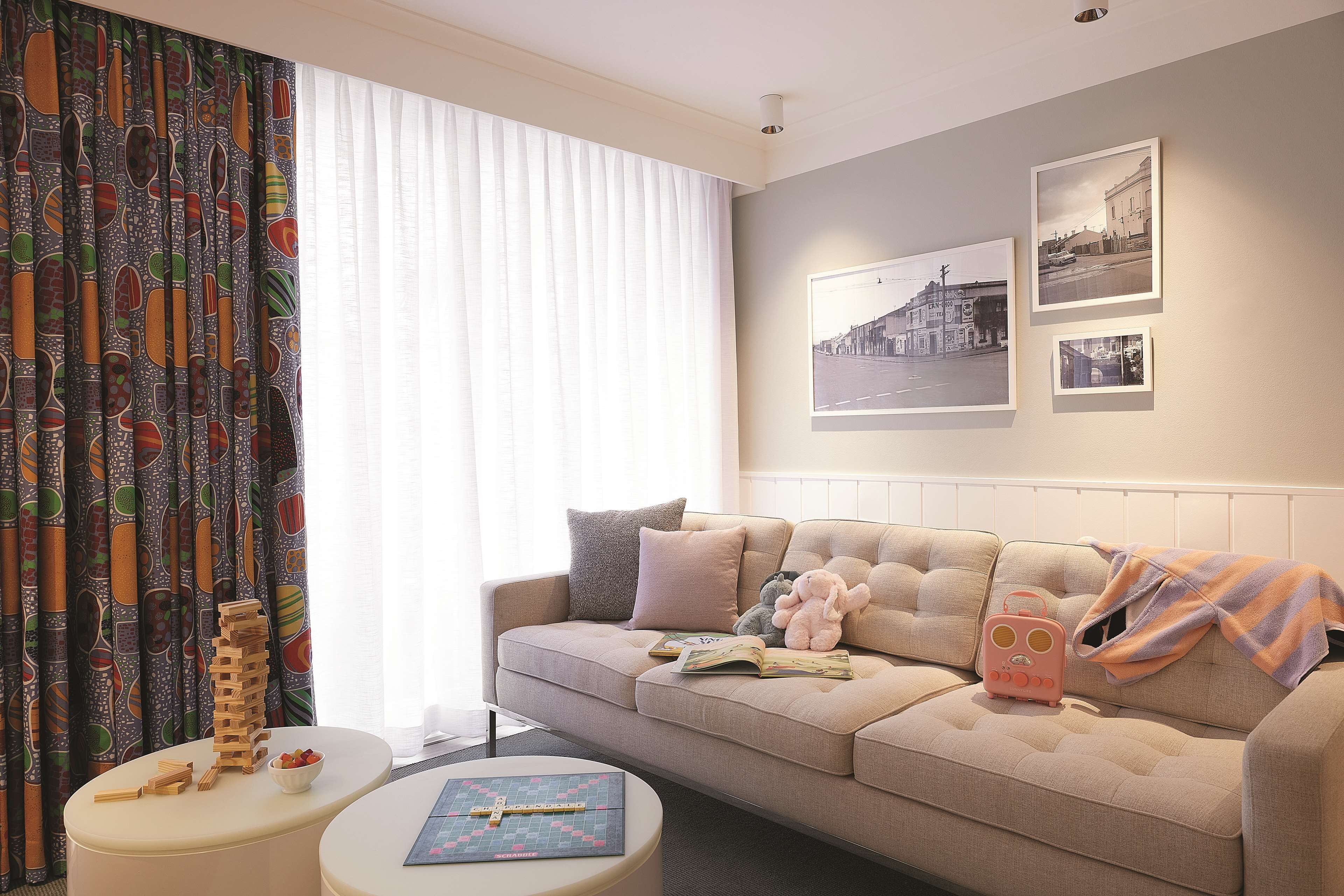 A living room with a sofa, a coffee table, and a stack of wooden blocks.