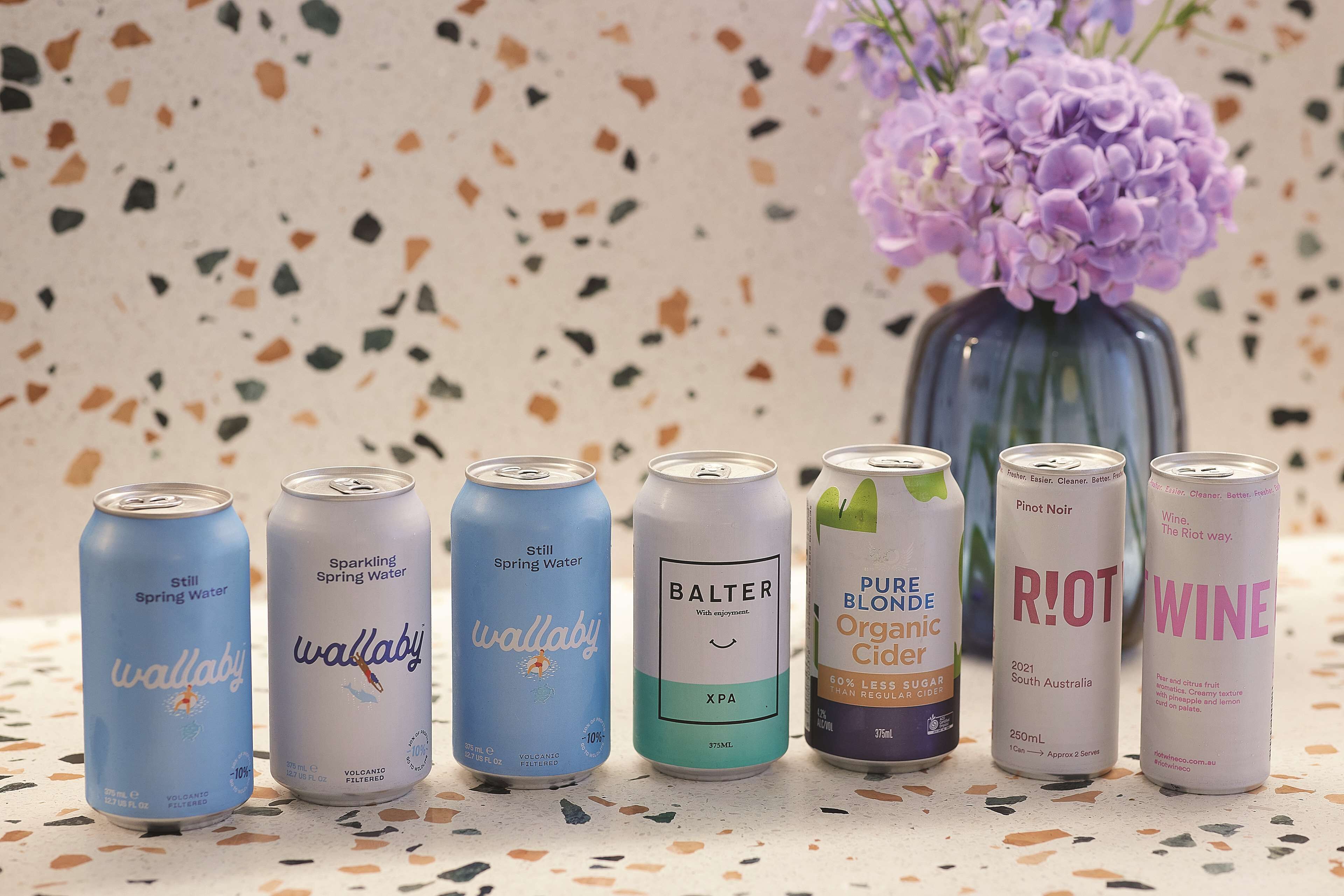 Une sélection de canettes de boissons disposées sur un comptoir à motifs.