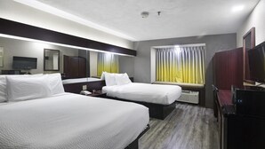 A hotel room with two beds, a TV, a desk, and a window with curtains. - Microtel Inn & Suites by Wyndham Meridian (Meridian)
