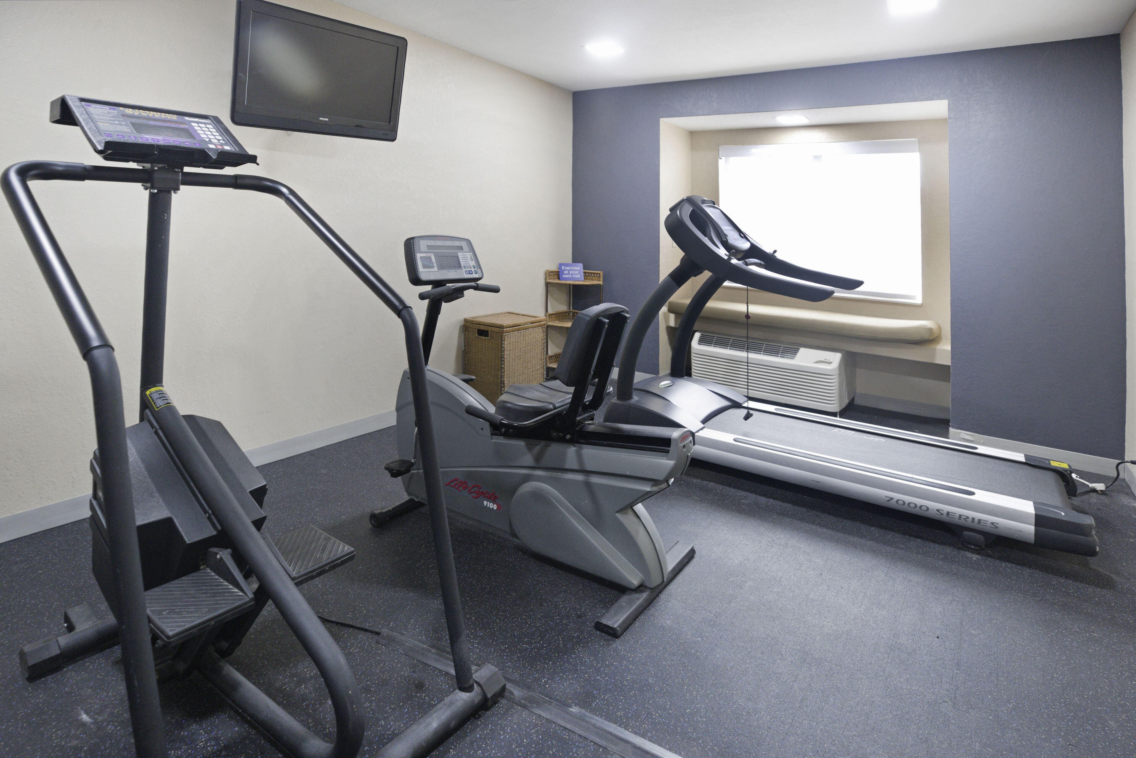 Ginásio com equipamentos de cardio, incluindo esteira, elíptico e bicicleta ergométrica.