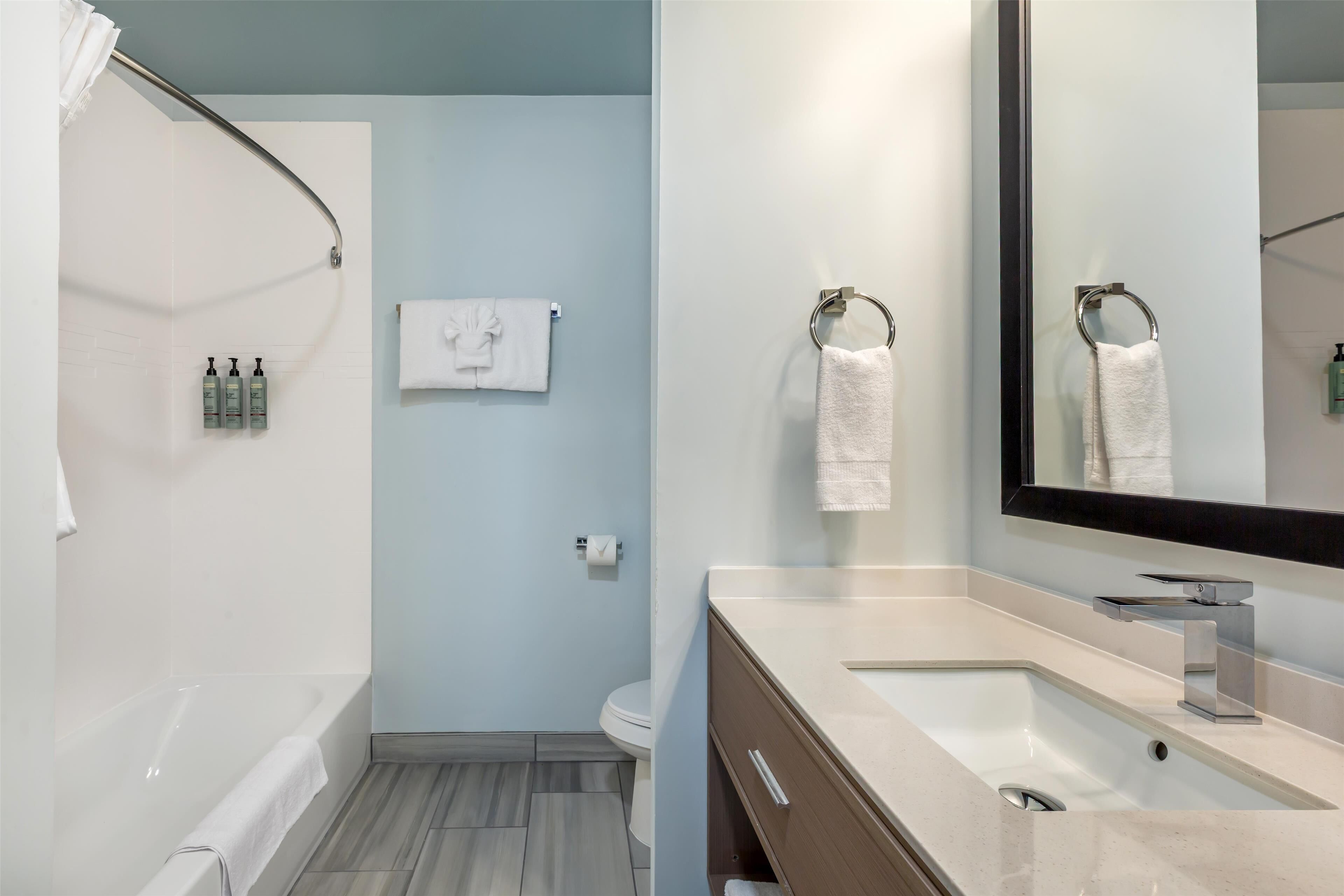 A modern bathroom with a bathtub, toilet, and sink.