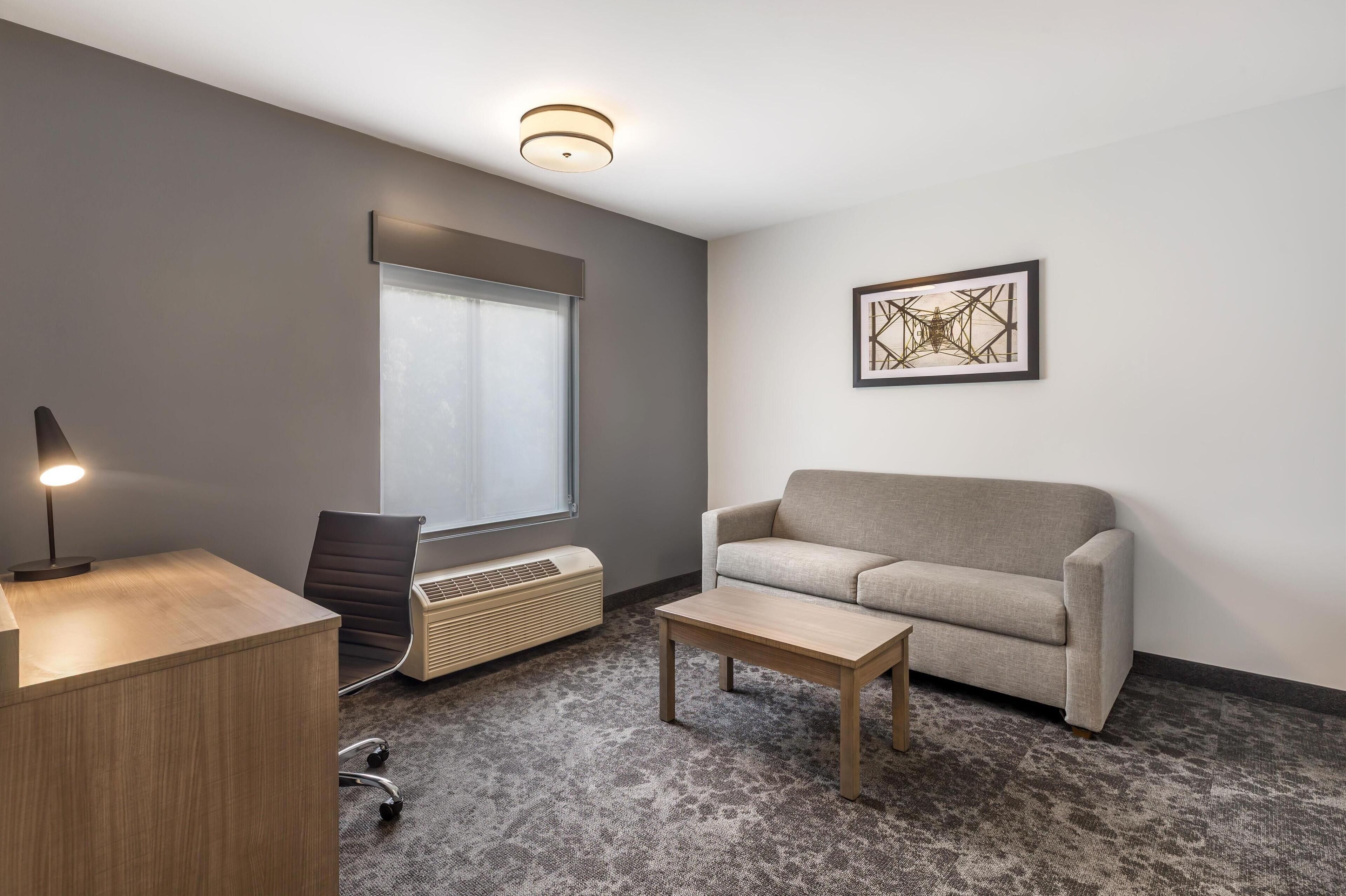 A modern office space with a desk, chair, and couch.