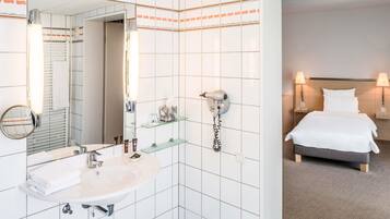 Ein Badezimmer mit Waschbecken, Spiegel und Fön an der Wand.