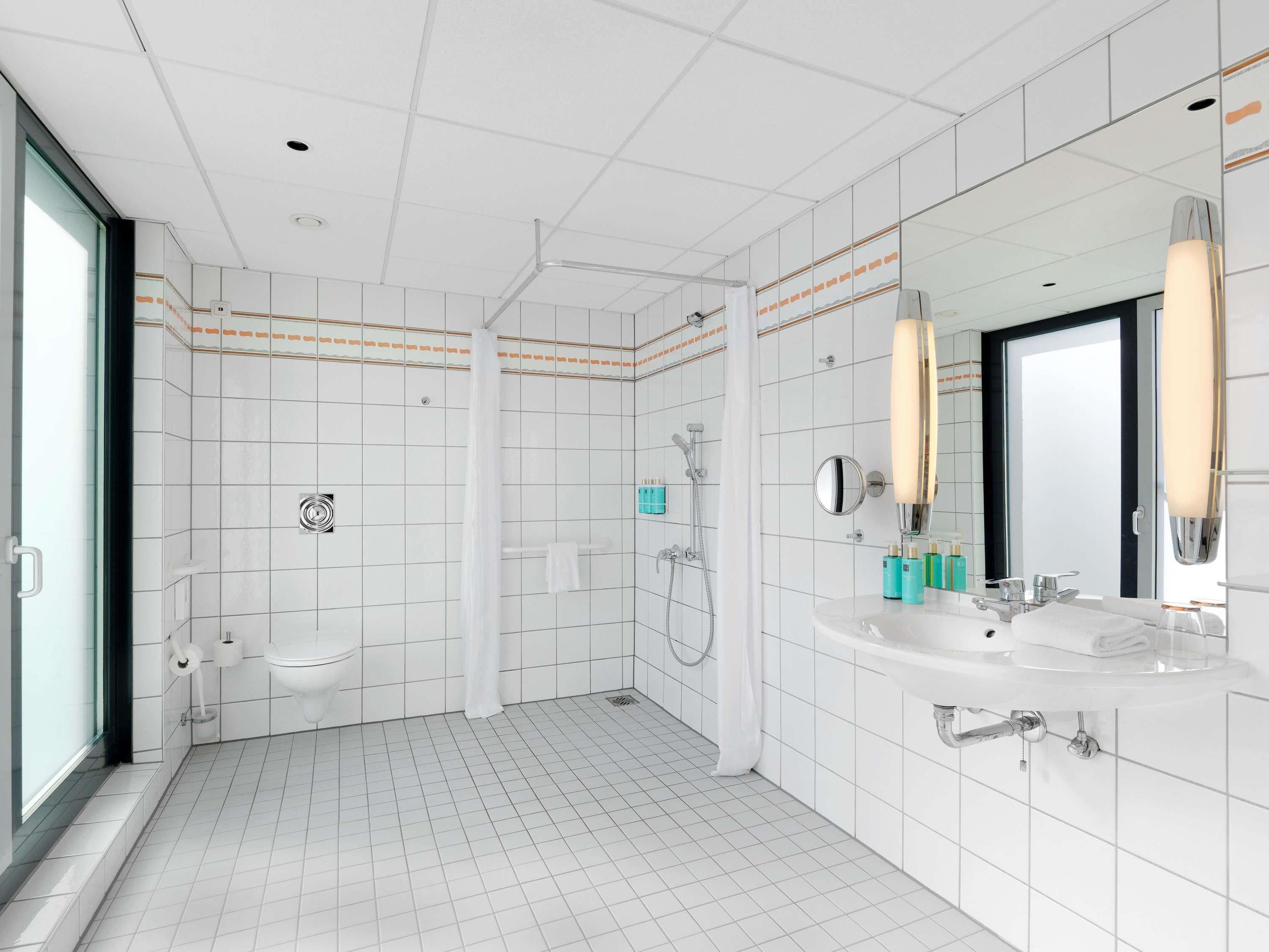 Et moderne badeværelse med badekar, bruser og håndvask.