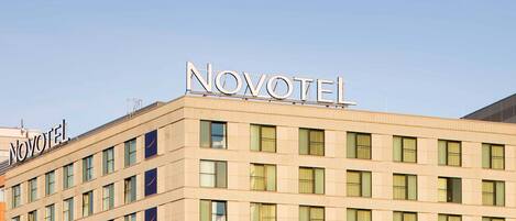 A hotel building with the name 'NOVOTEL' prominently displayed on the facade.
