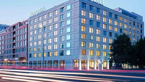A modern hotel with a prominent 'NOVOTEL' sign, multiple floors, and a well-lit facade. - Novotel Berlin Mitte (Berlin)