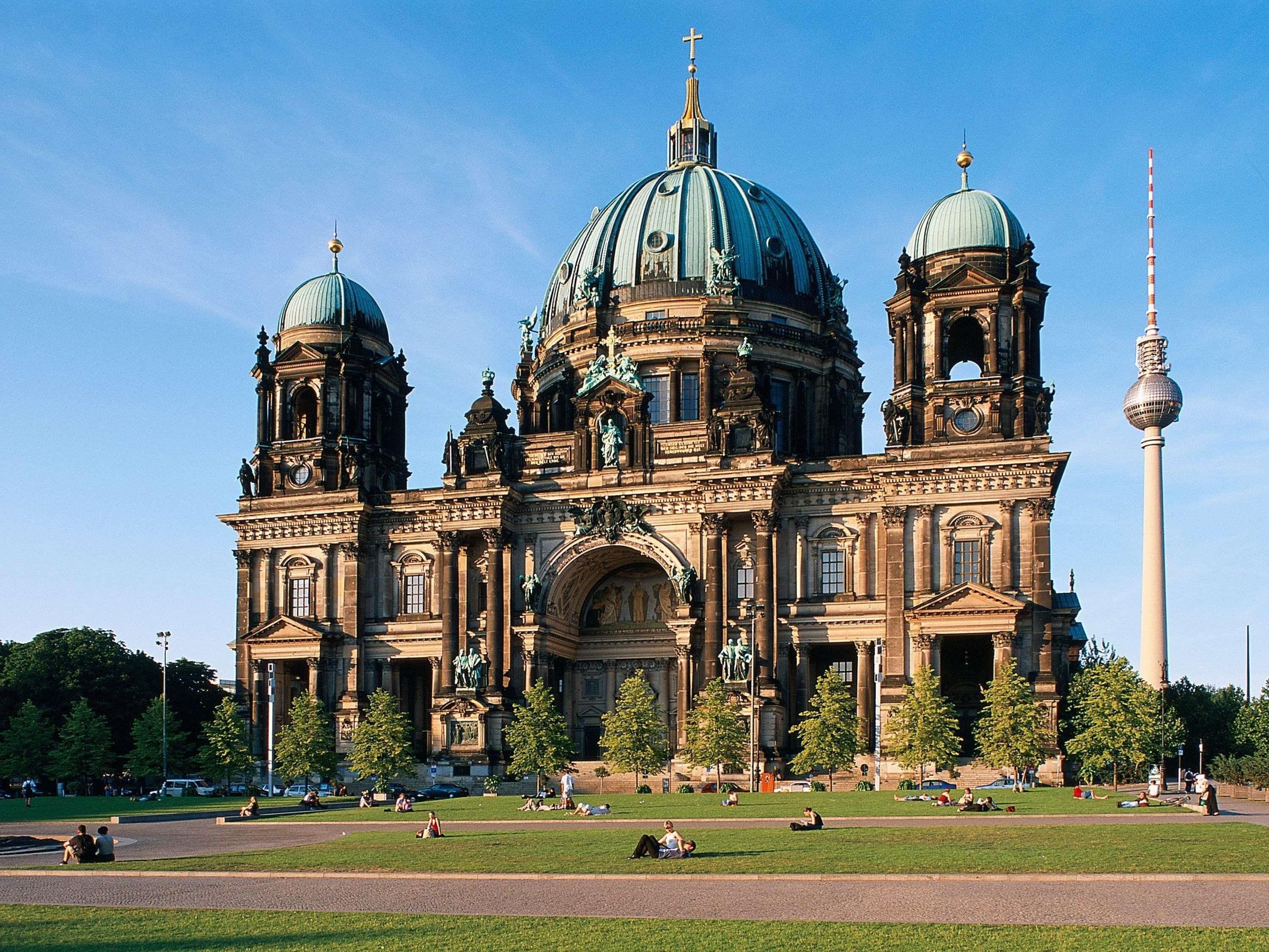 A large, historic building with multiple domes and a prominent tower.