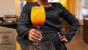 A person holding a cocktail glass on a marble countertop in a well-lit indoor setting. - Mercure Jaraguá do Sul Hotel (Jaragua do Sul)