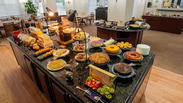 Un buffet proposant une variété de plats et un espace où l’on peut s’asseoir, avec des tables et des chaises.