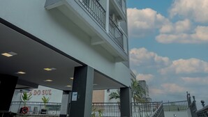 A modern building with a terrace featuring outdoor seating and a sign that reads "ADO SUL". - Mercure Jaraguá do Sul Hotel (Jaragua do Sul)