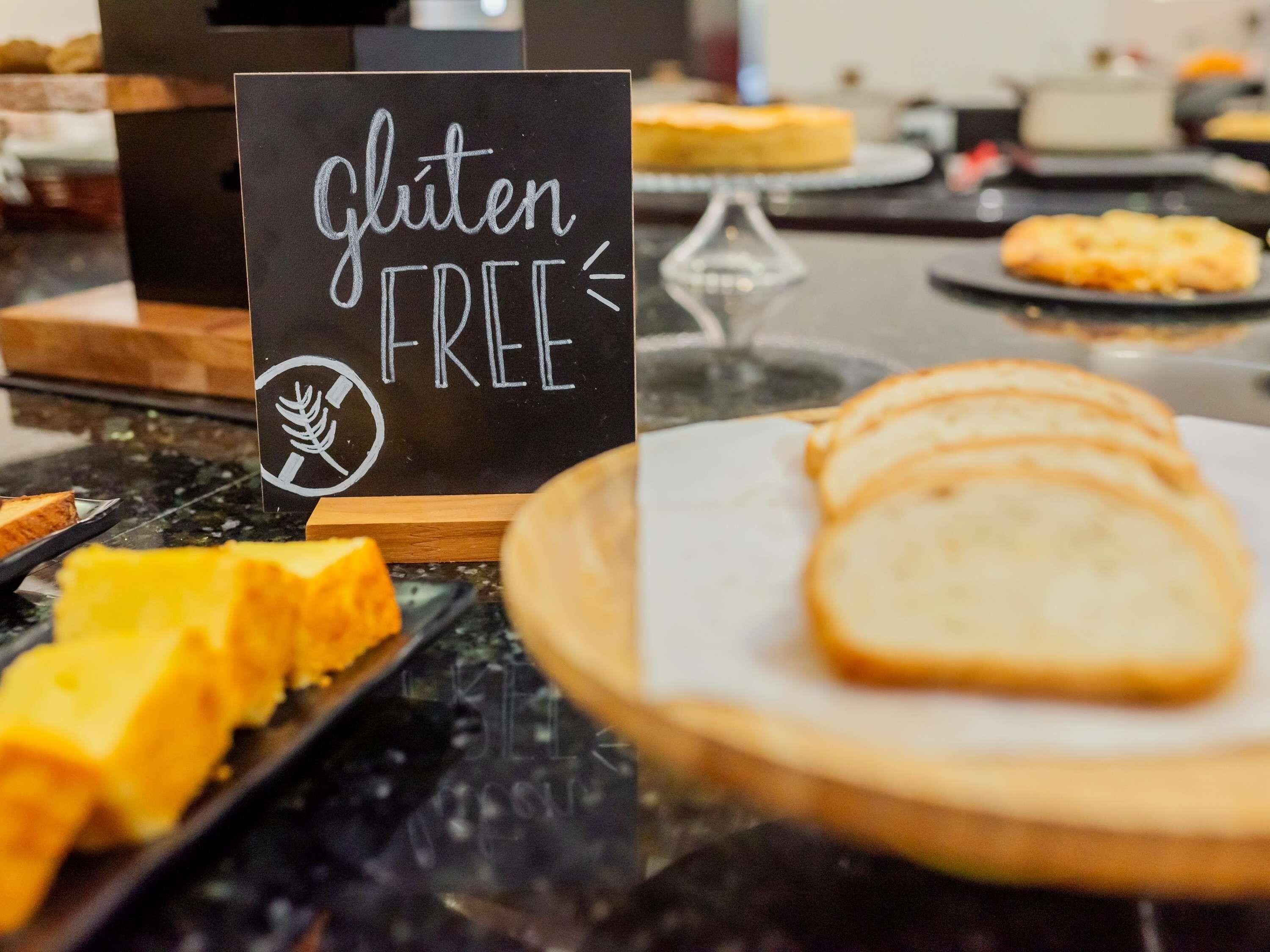 Mostrador de buffet con un cartel que indica opciones sin gluten.