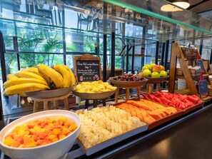 Esposizione di frutta con diversi tipi di frutta e un cartello in lingua straniera.